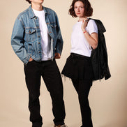 Two people standing side by side against a beige background