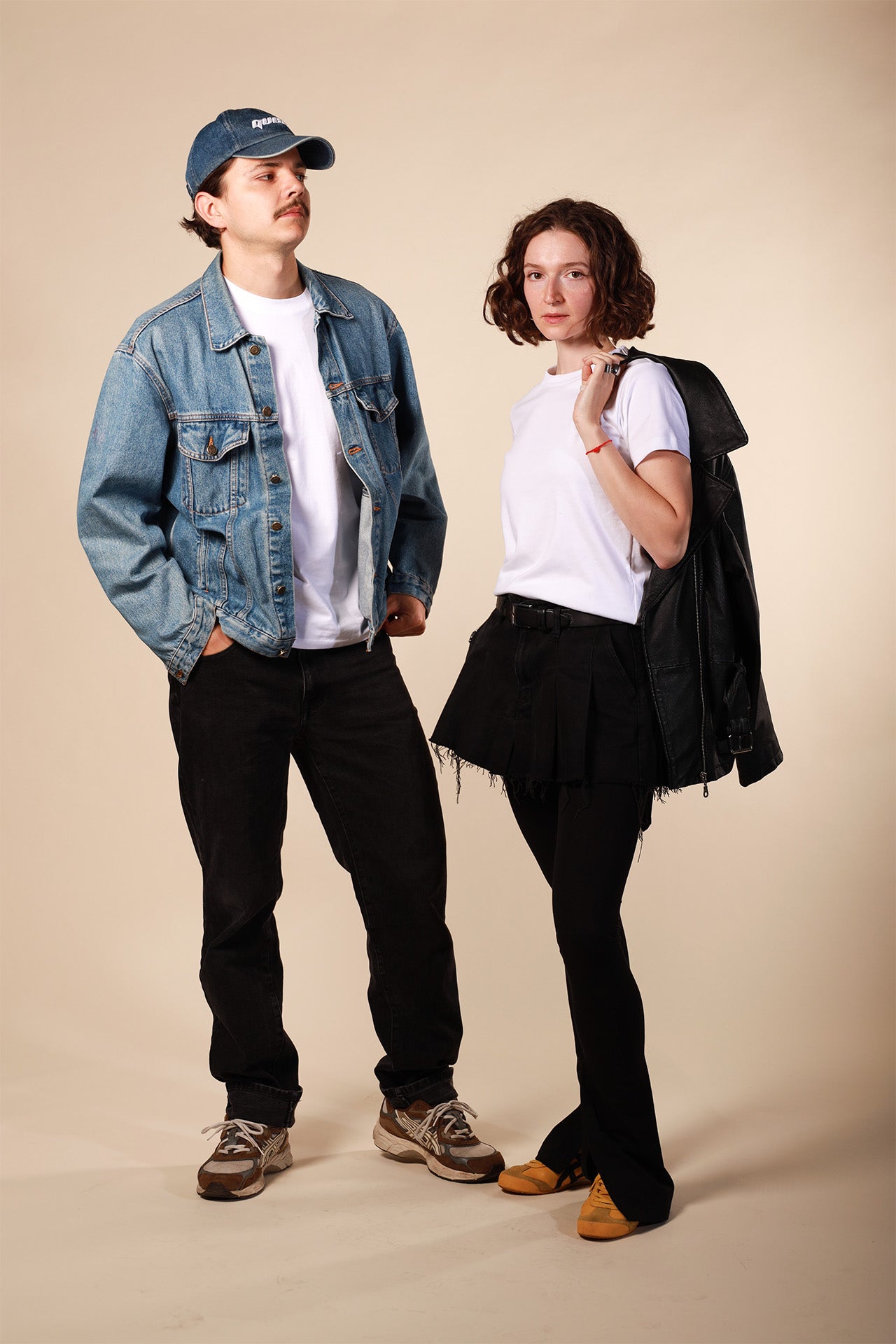 Two people standing side by side against a beige background