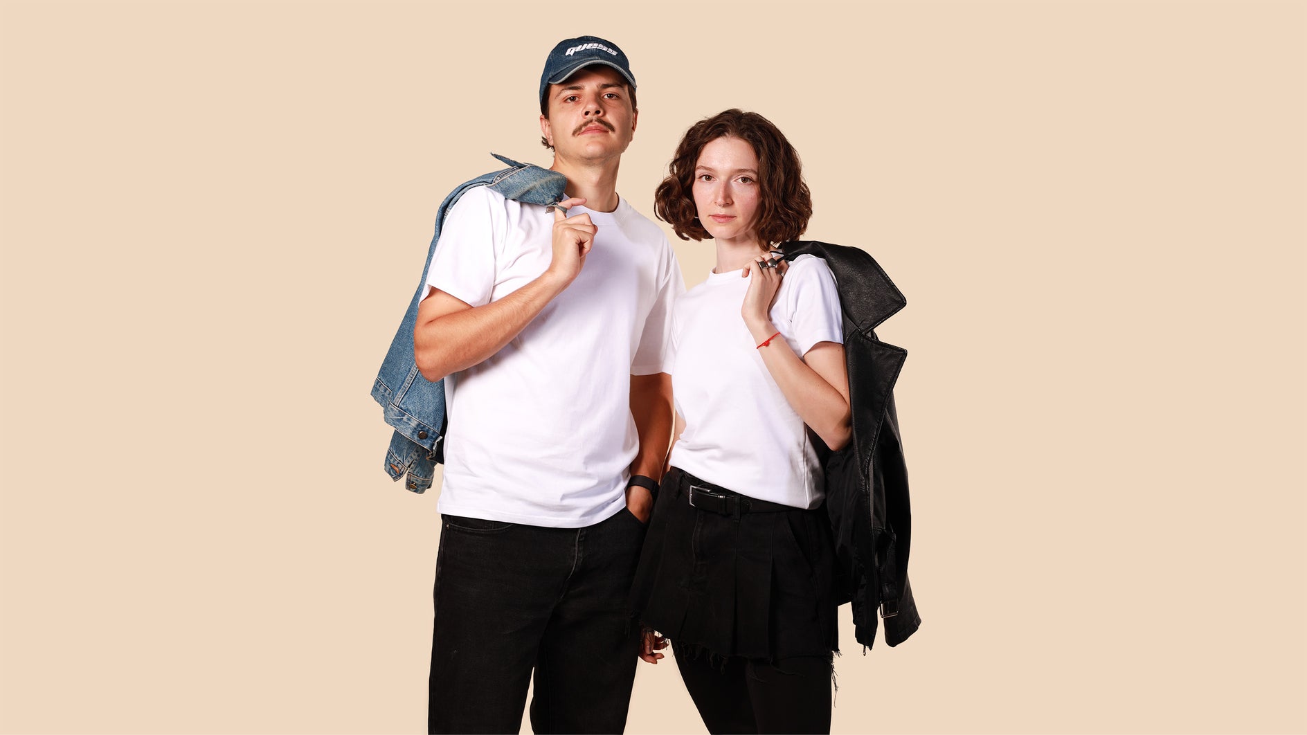 Two people standing side by side against a beige background