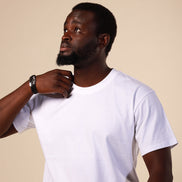 Man wearing a white t-shirt and striped pants against a beige background