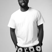 Man wearing a white t-shirt and black shorts with geometric pattern on a gray background