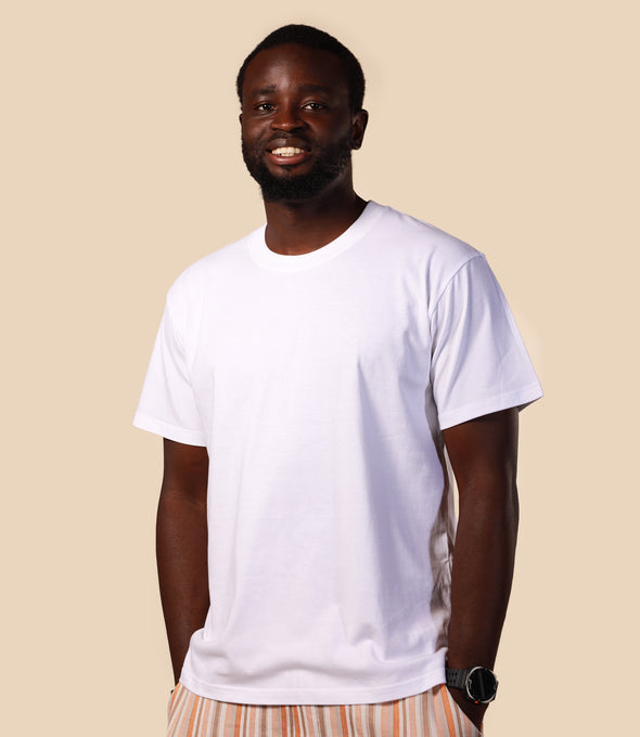Man wearing a plain white t-shirt against a beige background