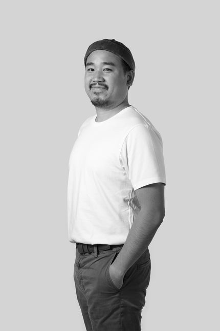 Person wearing a white t-shirt and cap on a plain background